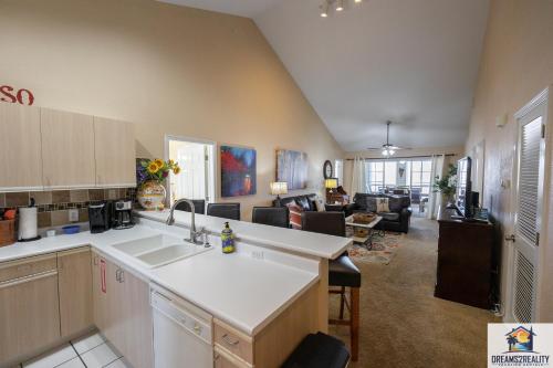 a kitchen with a sink and a living room at 3 BR Condo - Near the Strip - Jacuzzi Tub - Stairs Required - FREE TICKETS INCLUDED - CH4-5 in Branson