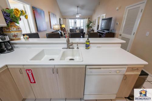 a kitchen with a sink and a living room at 3 BR Condo - Near the Strip - Jacuzzi Tub - Stairs Required - FREE TICKETS INCLUDED - CH4-5 in Branson