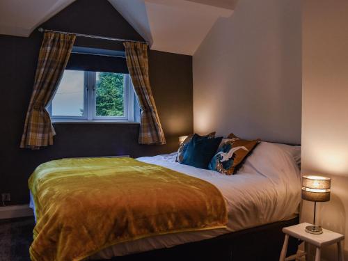 a bedroom with a large bed with a window at Stork Cottage in Conder Green