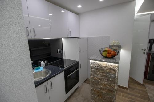 a kitchen with white cabinets and a sink at Vikendica na Drini - Drinska priča in Loznica
