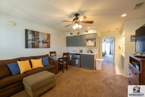a living room with a brown couch and a kitchen at 1BR Walk-In Condo with 2 Person Jacuzzi Tub - Near the Strip - FREE TICKETS INCLUDED - CH5-3 in Branson