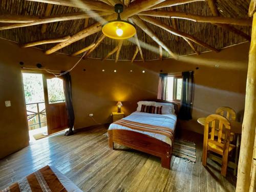 1 dormitorio con 1 cama y techo grande en Ekokuelap Lodge y turismo alternativo, en Nuevo Tingo