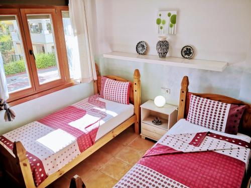 1 dormitorio con 2 camas individuales y ventana en Marina Esuri Golf y Playa, en Ayamonte