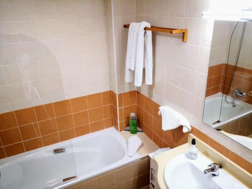 a bathroom with a tub and a sink and a toilet at Marina Esuri Golf y Playa in Ayamonte