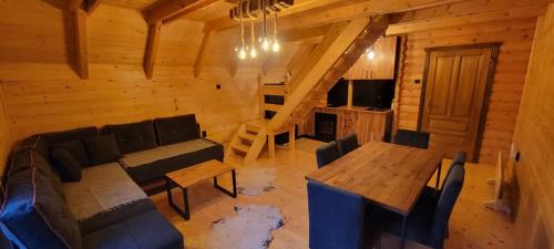 ein Wohnzimmer mit einem Sofa und einem Tisch in einer Hütte in der Unterkunft Apartmani Prica in Crni Vrh