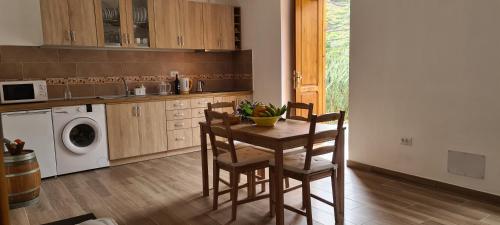 a kitchen with a table and chairs and a microwave at CASA RURAL ANTIGUA ESCUELA I in Hermigua