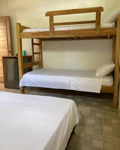 Ce dortoir comprend 2 lits superposés et des draps blancs. dans l'établissement Habitación privada en la playa HappyBeach_co, à San Antero