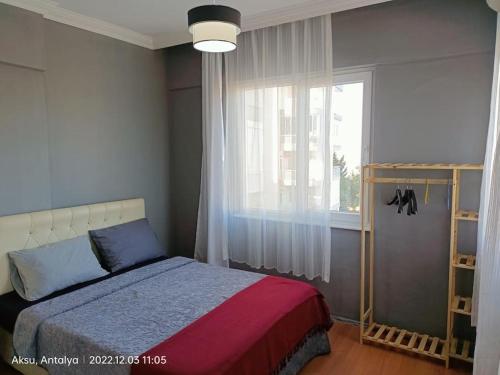 a bedroom with a bed and a large window at 3+1 daire.hızlı Wifi,havalimanı plaj, market yakın in Antalya