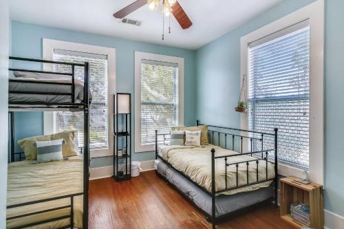 Un dormitorio con dos literas y dos ventanas. en A Bended Oak Bungalow, en Galveston