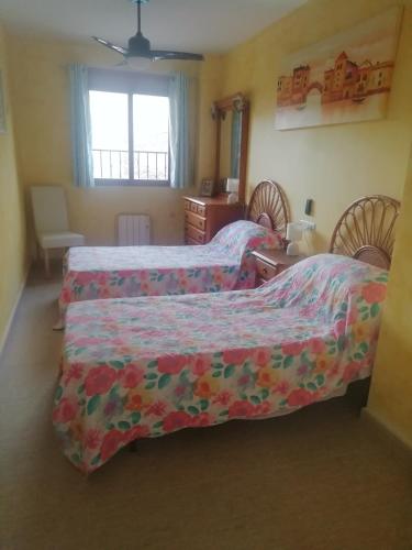1 Schlafzimmer mit 2 Betten, einem Tisch und einem Fenster in der Unterkunft Cruz de Vino in Caravaca de la Cruz