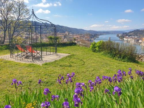 a bench on a hill with purple flowers at La Bâtie - Vue imprenable - Amazing view - Parking privé in Vienne