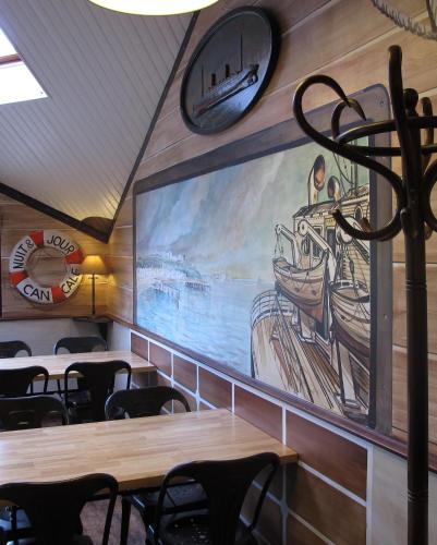 a dining room with tables and a large screen at Hotel Nuit Et Jour - La Maison de Lucile in Cancale