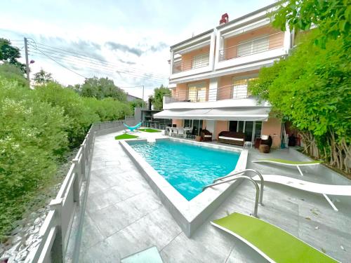 uma piscina em frente a uma casa em DolceVita Villa em PalaiónTsiflíkion