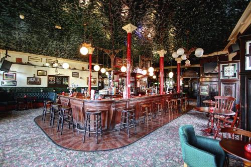 a bar in a pub with tables and chairs at Beaconsfield Hotel in London