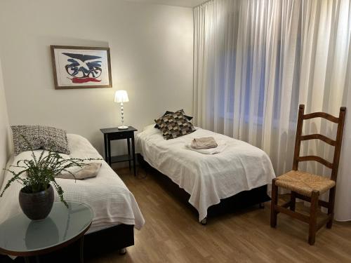 a room with two beds and a table and a chair at Art Guesthouse Olla in Selfoss