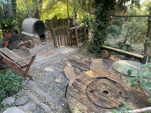 a garden with a wood fired oven and a bench at Cabaña alpina en plena cordillera con acceso a Río in Río Blanco
