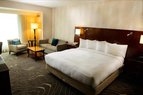 a hotel room with a large bed and a chair at Rochester Marriott Mayo Clinic Area in Rochester