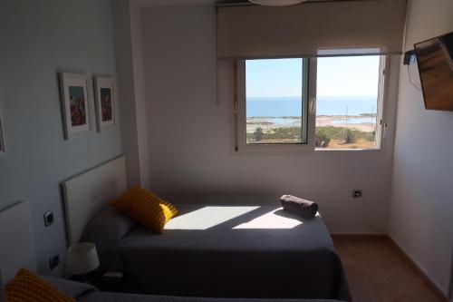 een kleine slaapkamer met een bed en een raam bij EL REMANSO IV in La Manga del Mar Menor