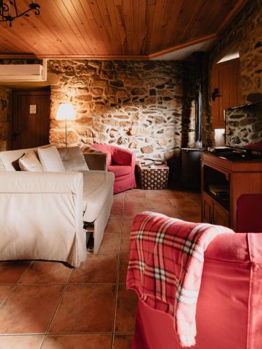 a bedroom with two beds and a stone wall at Quinta de Recião in Lamego
