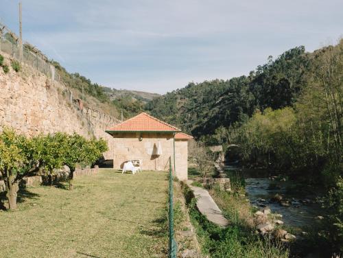 un edificio junto a un río junto a una montaña en Quinta de Recião, en Lamego