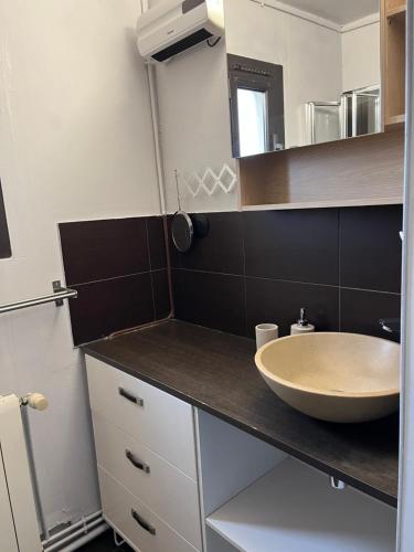 une salle de bain avec un lavabo et un miroir dans l'établissement Sun escape, appart rénové climatisé 3 pièces 4-6 pers, 350m de la plage, à Marseille