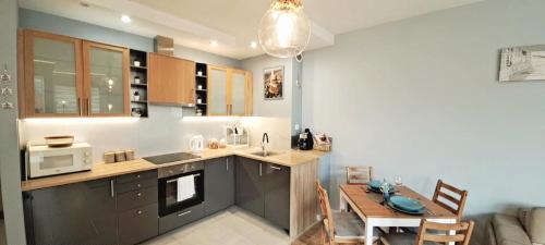 a kitchen with a table and a dining room at Marine Apartament in Gdańsk