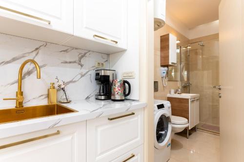 a bathroom with a sink and a washing machine at Luxa 5 min old town, 10 min airport in Trogir