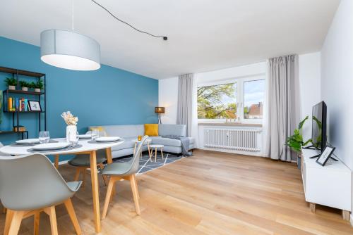 a dining room and living room with a table and chairs at E&K living - design apartment - SKY-TV - kitchen - free parking in Augsburg