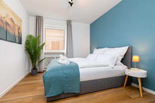 Un dormitorio con una cama y una planta en una habitación en E&K living - design apartment - 2 bedrooms - kitchen - free parking, en Augsburg