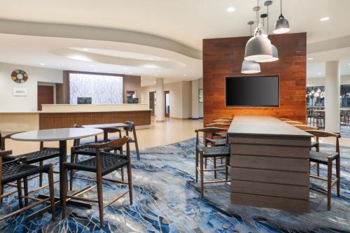 a lobby with tables and chairs and a flat screen tv at Fairfield Inn & Suites Orlando Ocoee in Orlando
