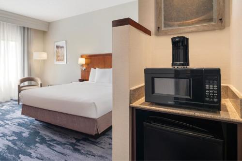 a hotel room with a bed and a microwave at Fairfield Inn & Suites Orlando Ocoee in Orlando