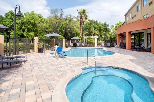 a pool at a resort with tables and chairs at Fairfield Inn & Suites Orlando Ocoee in Orlando