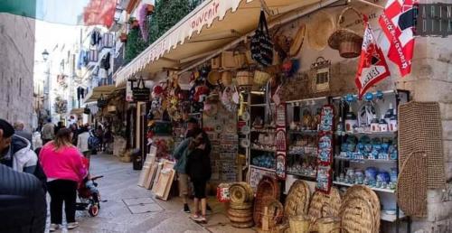 a group of people walking down a street in a market at B&B Romeo in Bari