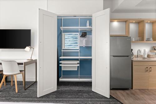 an open kitchen with a desk and a refrigerator at TownePlace Suites by Marriott Cape Canaveral Cocoa Beach in Cape Canaveral