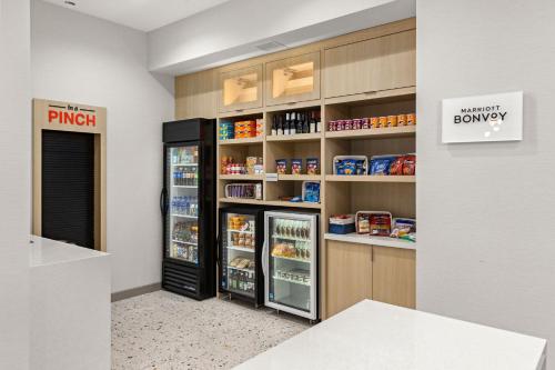 a store with a refrigerator and shelves of food at TownePlace Suites by Marriott Cape Canaveral Cocoa Beach in Cape Canaveral