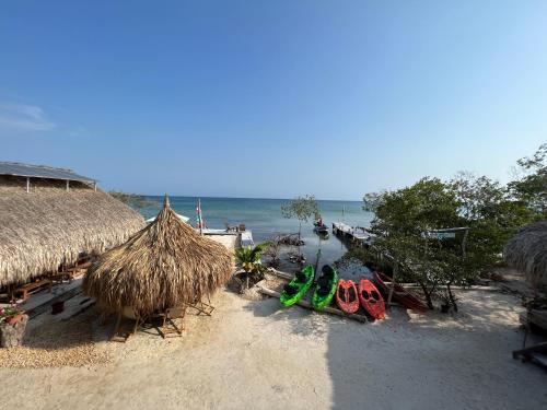 a beach with a hut and kayaks on the beach at Santa Lova Eco-hostel Isla Tintipan in Tintipan Island