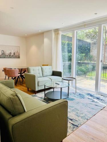a living room with a couch and a table at Luxury 2 Bed 2 Bathroom apt near tube station! in London
