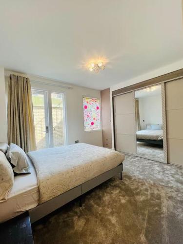 sypialnia z dużym łóżkiem i dużym lustrem w obiekcie Luxury 2 Bed 2 Bathroom apt near tube station! w Londynie