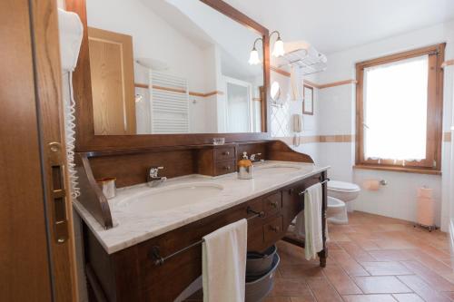 CaianoにあるBorgo Caiano Country Innの洗面台、鏡、トイレ付きのバスルーム