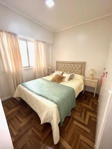 Un dormitorio con una cama con una manta verde. en DEPTO EN MAR DEL PLATA en Mar del Plata