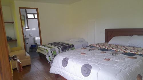 a bedroom with two beds in a room at Sendero de las aves in Mindo