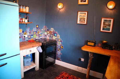 a kitchen with a blue wall with a stove at Grand top floor apartment in the Royal Bank House in Maybole
