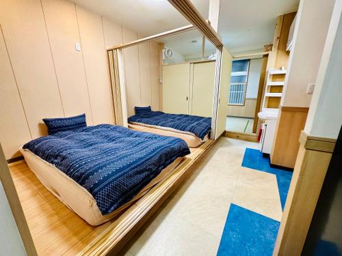 2 Betten in einem Zimmer mit Spiegel in der Unterkunft MoRi House IN 伊勢佐木町 in Yokohama