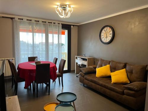 - un salon avec un canapé et une table avec un réveil dans l'établissement Sun escape, appart rénové climatisé 3 pièces 4-6 pers, 350m de la plage, à Marseille