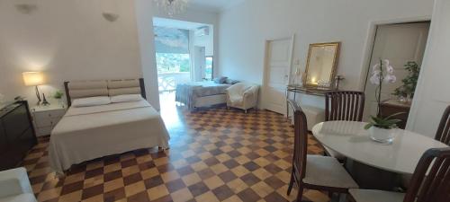 uma sala de estar com uma cama e uma mesa e um quarto em Palácio Quitandinha Espetacular Apartamento com Vista para o Lago em Petrópolis