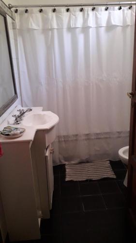 a bathroom with a sink and a shower curtain at Casa Quinta in Colonia Caroya