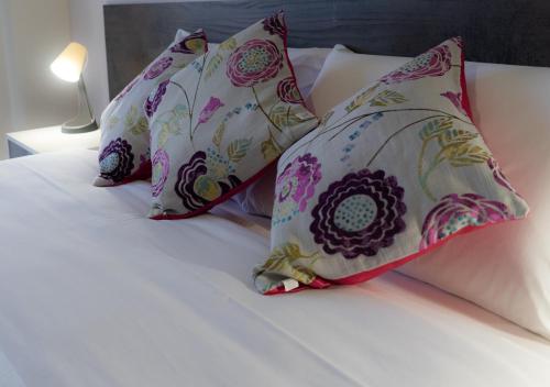 a bed with four pillows on top of it at PAPALi 289 in Catania