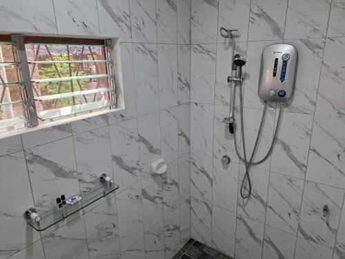 La salle de bains est pourvue d'une douche et de carrelage blanc. dans l'établissement Private 1-BR Bungalow in Moalboal, à Moalboal