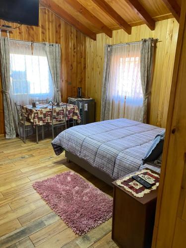 a bedroom with a bed and a dining room with a table at Donde Jose Cabañas y Restaurant in Manzanar