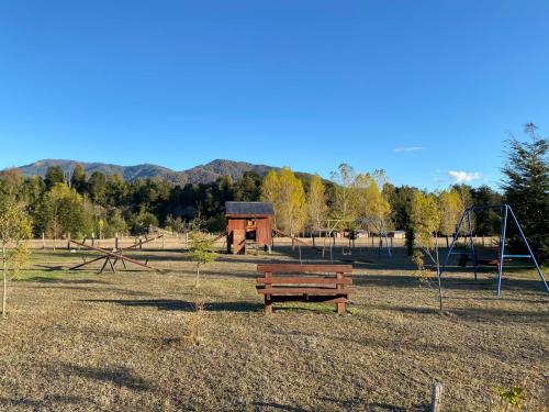 a park with a bench and a playground at Donde Jose Cabañas y Restaurant in Manzanar